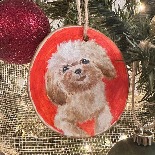 Ornament of Pet Portrait of a Shit Zhu Dog with a red background, hanging on a christmas tree with green and red glitter ornaments behind and a gold ribbon. Close up of pet portrait ornament 