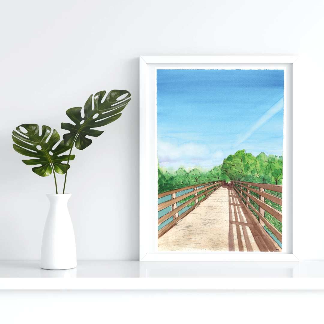 photo of BC, Canada trail on a bridge surrounded by sjrubs and forests and a river in a picture frame with greenery surrounding